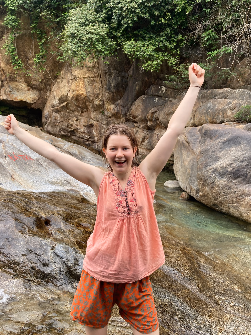 Mia Ruby Harrison celebrating beside a rocky river
