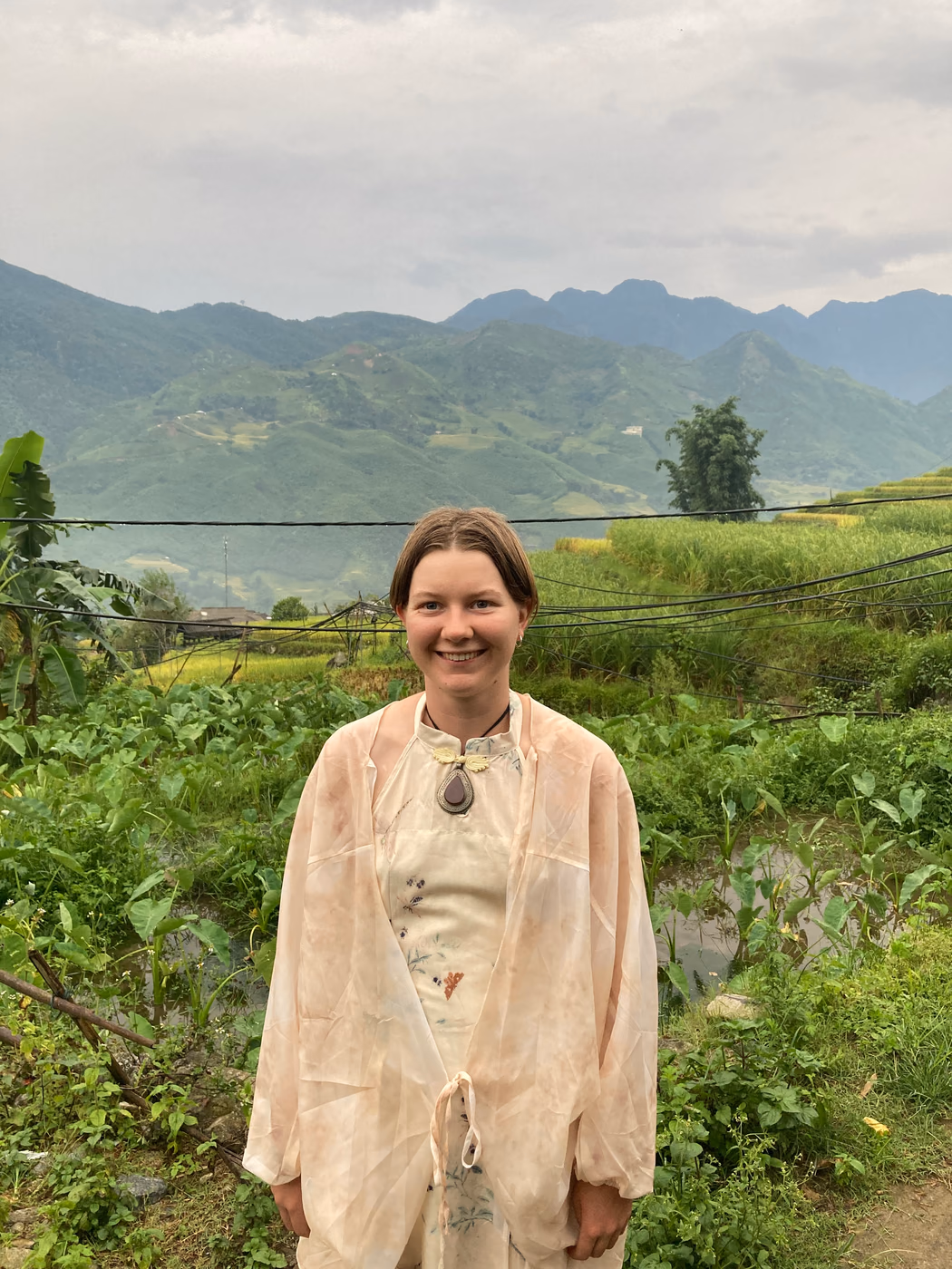 Mia Ruby Harrison standing among green rice terraces in Vietnam